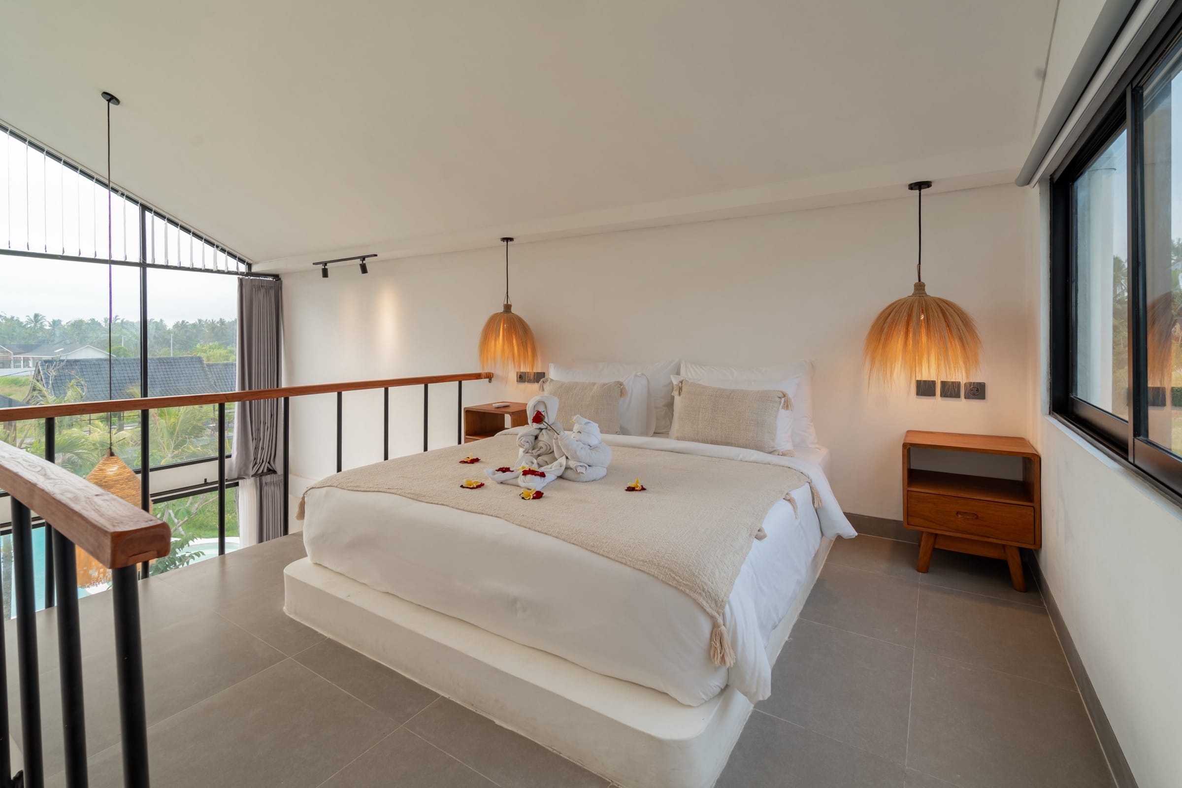 Mezzanine bedroom with the bed facing a gable window over the rice field