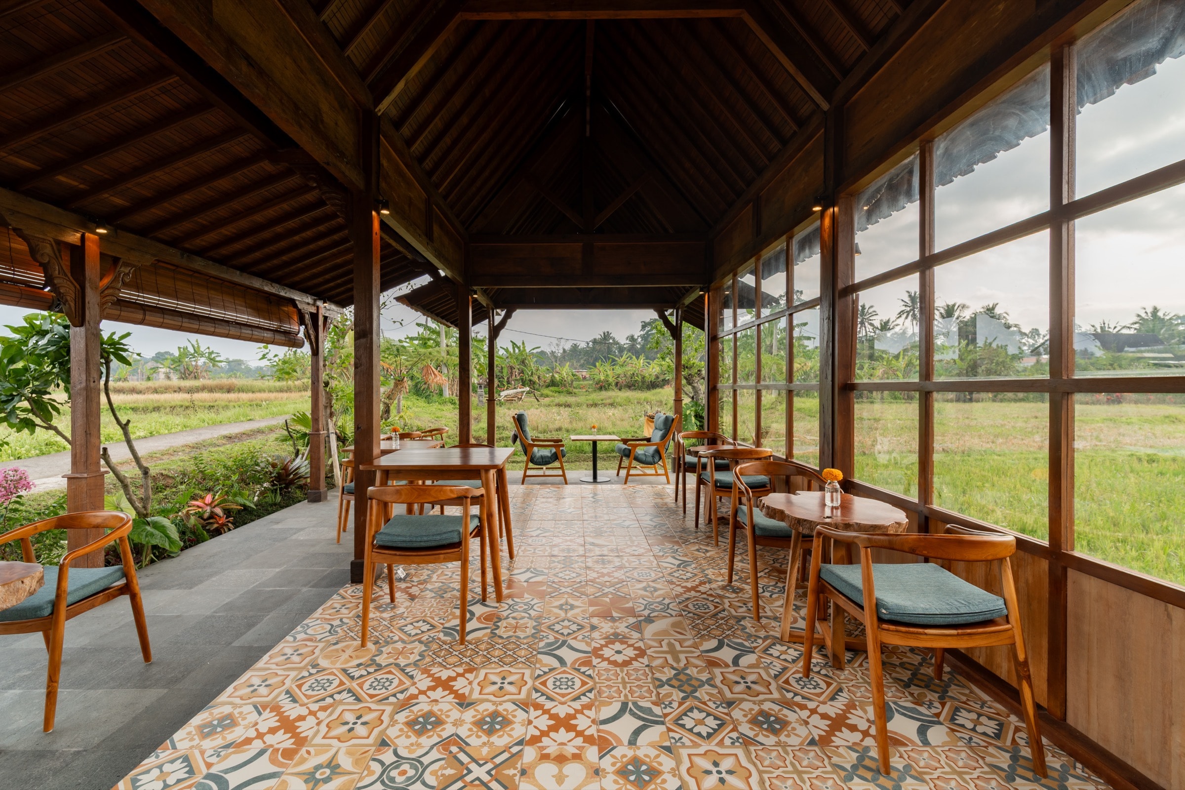 Sapa Sorai's open timber pavilion, set with tables and teal-cushioned chairs, looking out onto the rice field